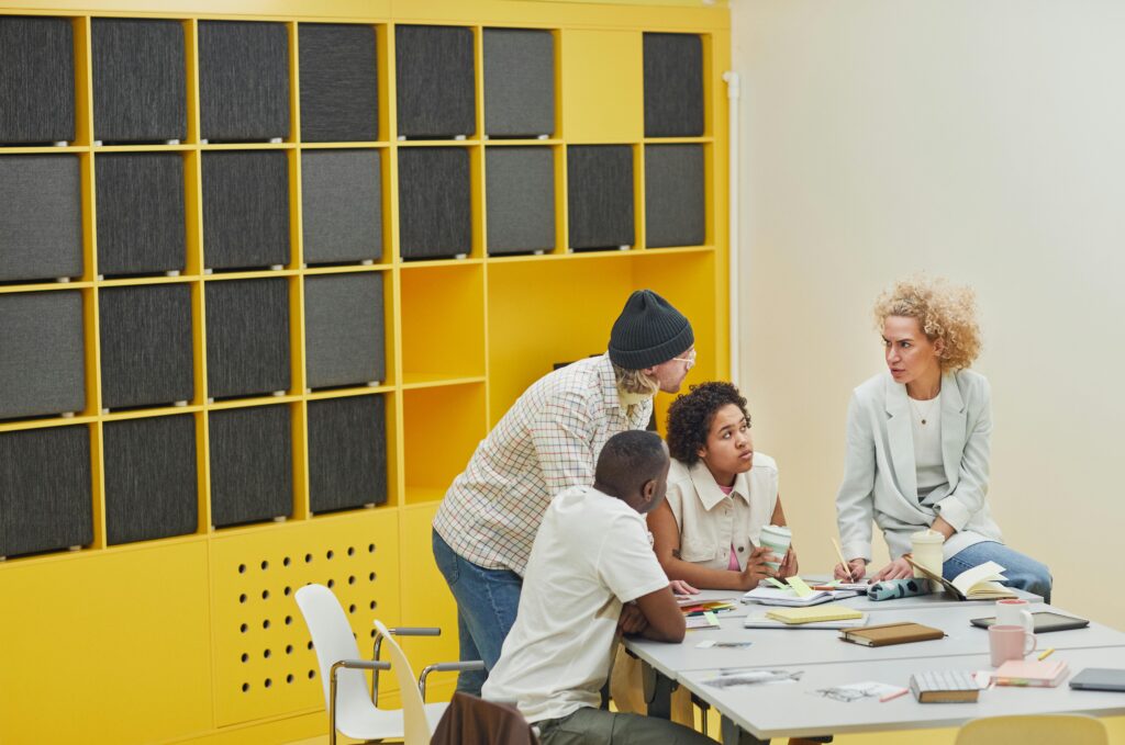 Colleagues engaged in a collaborative meeting in a modern, colorful office space.